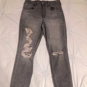 Stretchy gray skinny jeans distressed with rips.
